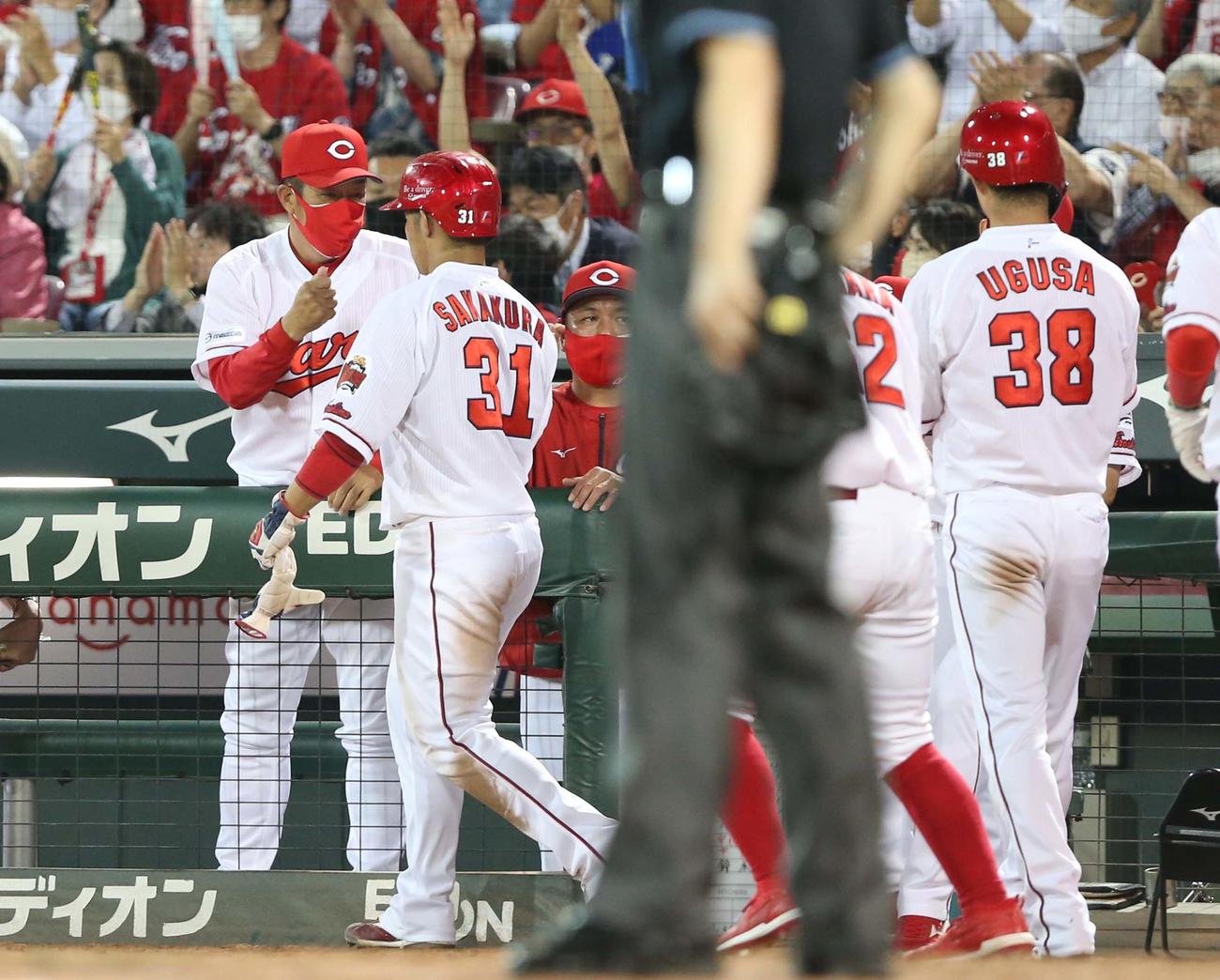 広島対日本ハム　5回裏、生還した選手を出迎える佐々岡監督（撮影・黒川智章）