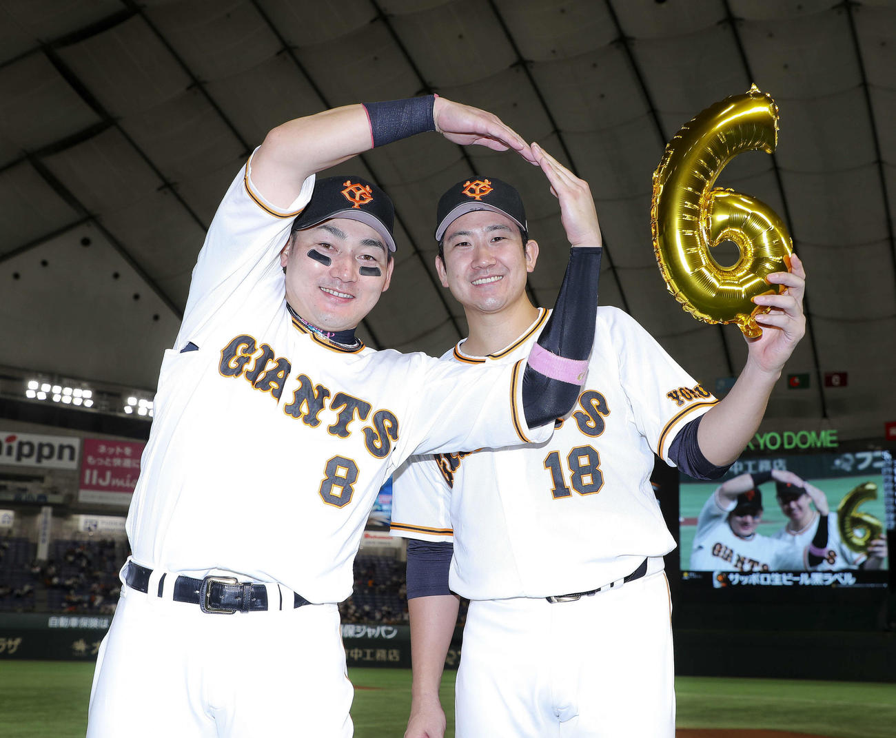 ソフトバンクに勝利し、2本塁打を放った丸（左）と8回無失点の好投で6勝目を挙げた菅野は笑顔で写真に納まる（撮影・河田真司）