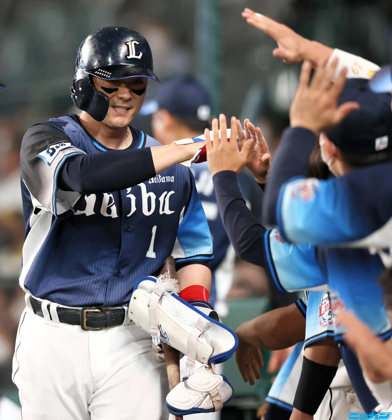 阪神対西武　7回表西武1死一、二塁、代打栗山（左）は右前適時打を放ち交代となり、ナインの出迎えに笑顔を見せる（撮影・上山淳一）