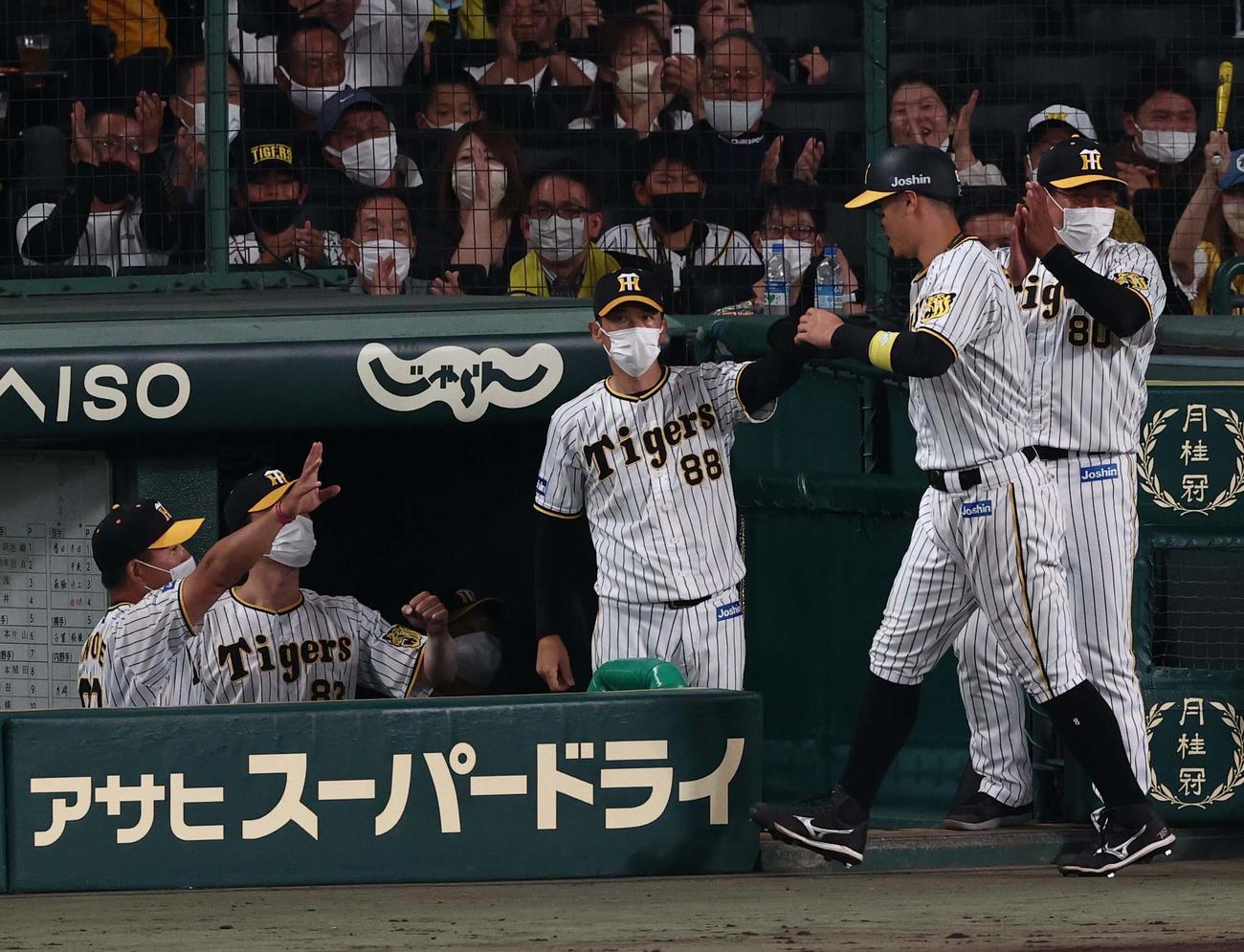 阪神対西武　7回裏阪神1死二、三塁、矢野監督（中央）は糸原の適時打で生還した佐藤輝を出迎える（撮影・上田博志）