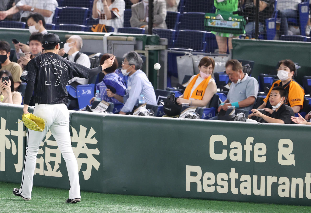 巨人対ロッテ　試合直前のキャッチボールを終え、少年ファンにボールをプレゼントするロッテ先発の佐々木朗（撮影・狩俣裕三）