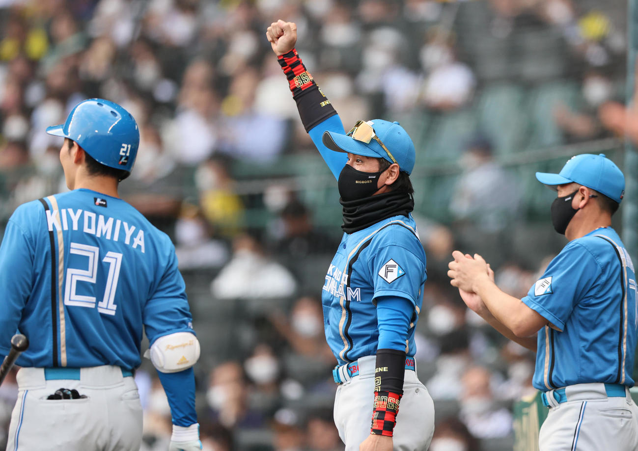 阪神対日本ハム　1回表日本ハム無死一塁、新庄監督（中央）は万波の先制左適時二塁打でガッツポーズする（撮影・上山淳一）