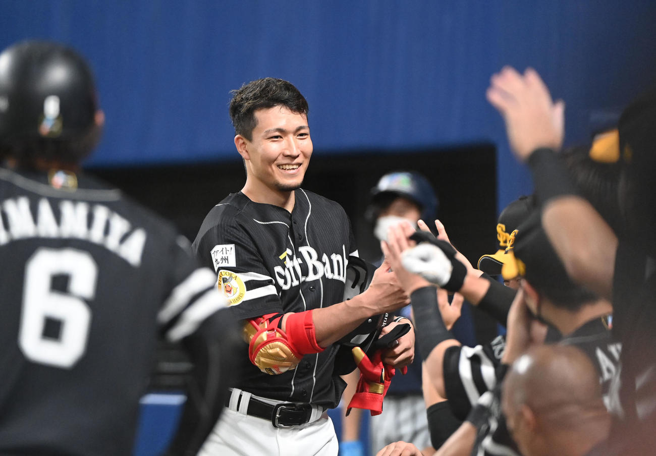 中日対ソフトバンク　4回表ソフトバンク1死二、三塁、先制の左犠飛を放ちナインと笑顔でタッチを交わす千賀（中央）（撮影・森本幸一）