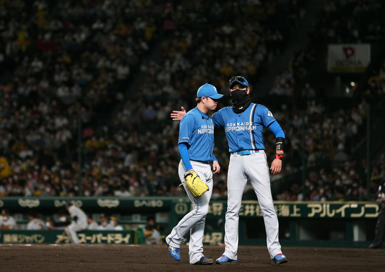 阪神対日本ハム　8回途中、降板する日本ハム堀（左）をねぎらう新庄監督（撮影・上山淳一）
