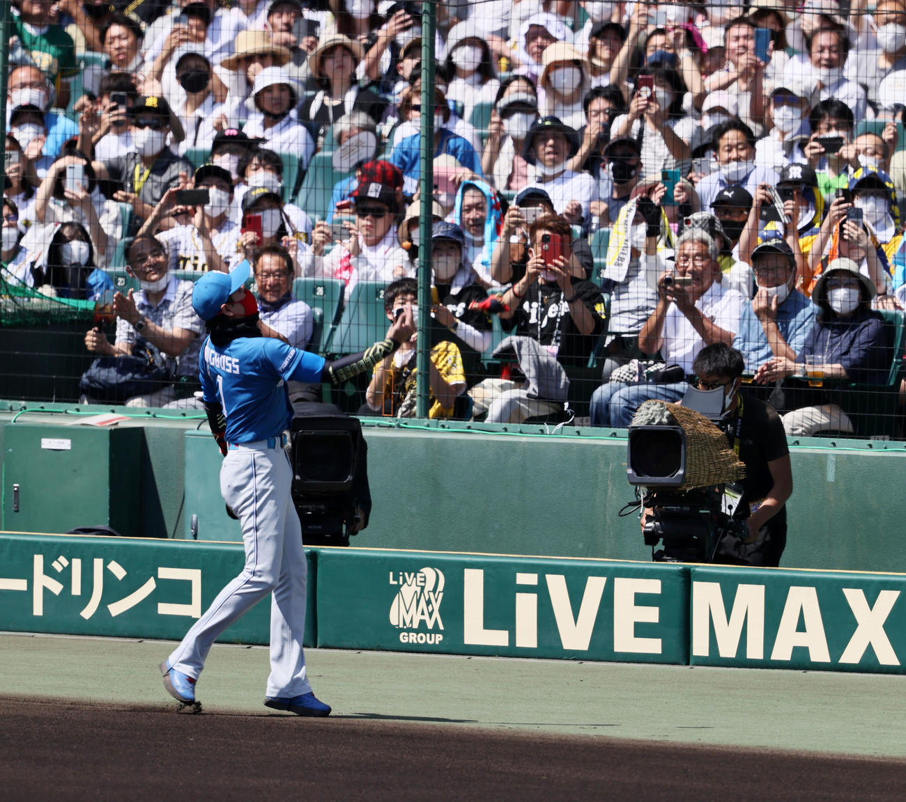 阪神対日本ハム　メンバー表交換を終えスタンドにリストバンドをプレゼントする新庄監督（撮影・加藤哉）