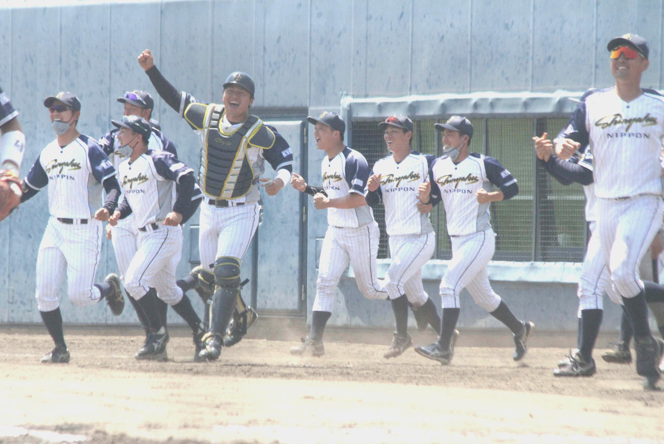 延長10回の接戦を制してベンチ前で喜ぶ日本新薬ナイン