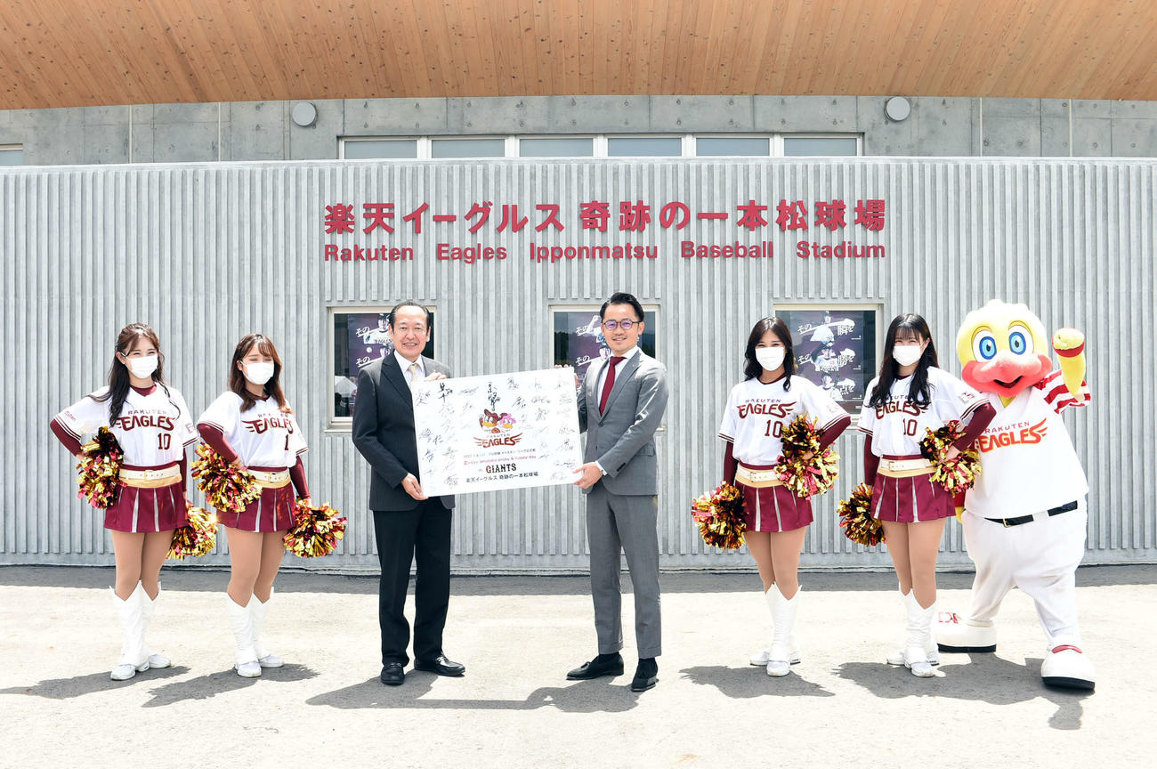 記念パネルを手に笑顔の戸羽市長（中央左）と楽天米田社長
