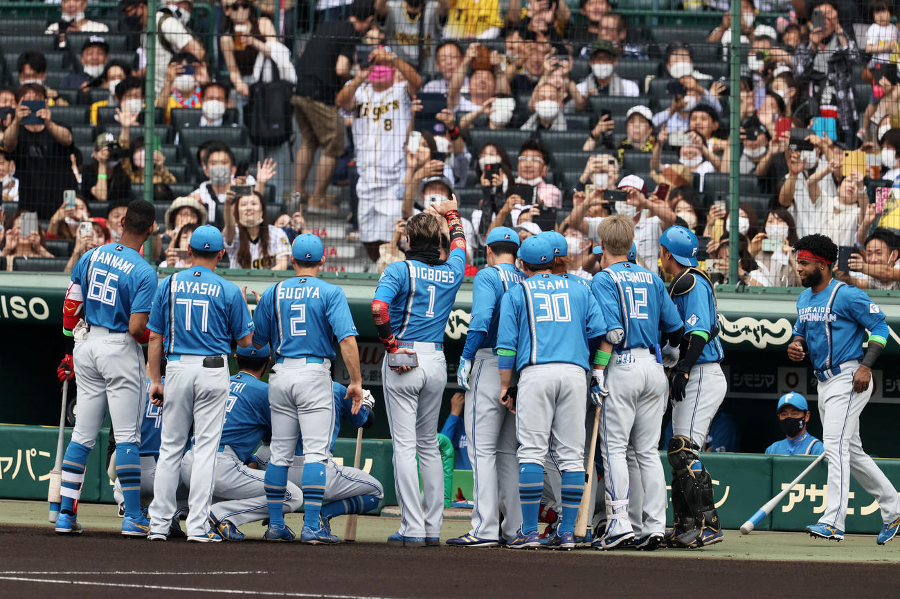 阪神対日本ハム　メンバー表交換を終ベンチ前でナインとともに写真に収まる新庄監督（撮影・加藤哉）