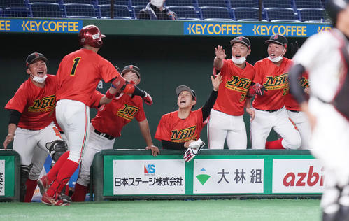 松山大対日本文理大 6回裏日本文理大2死二塁、先制の2点本塁打を放った野元(左から2人目)を笑顔で迎えるナイン(撮影・鈴木みどり)