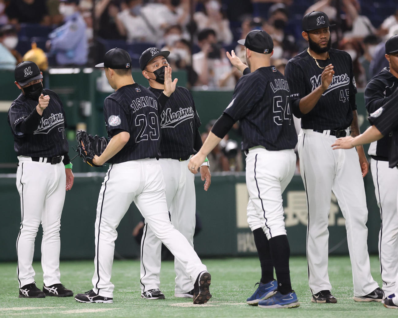 巨人対ロッテ　試合後、レアード（中央右）を迎える井口監督（撮影・狩俣裕三）