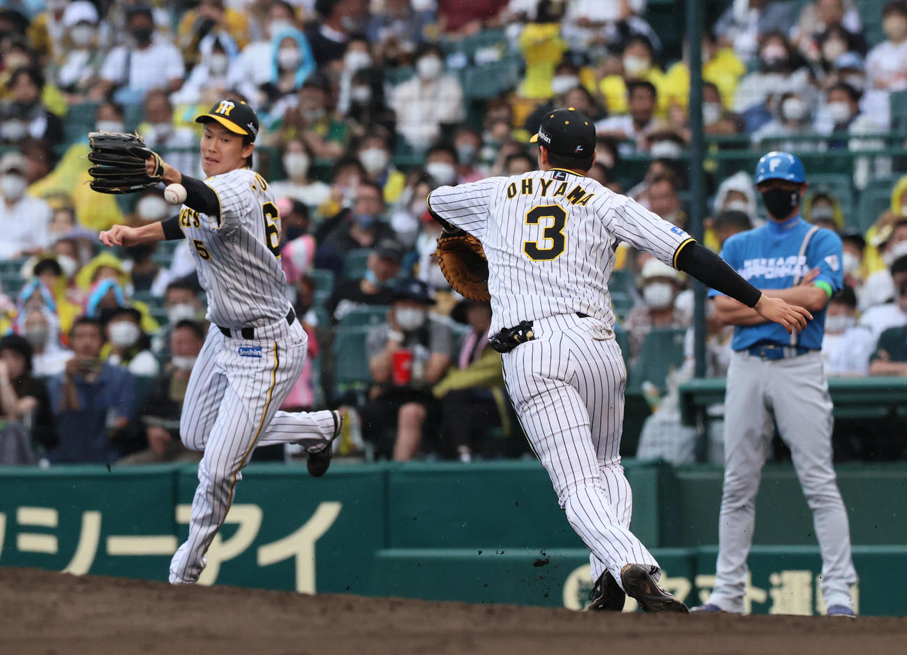 阪神対日本ハム　8回表日本ハム2死、代打浅間の一ゴロで、湯浅（左）はカバーに入るも一塁手大山の送球がそれ落球し出塁される（撮影・上山淳一）