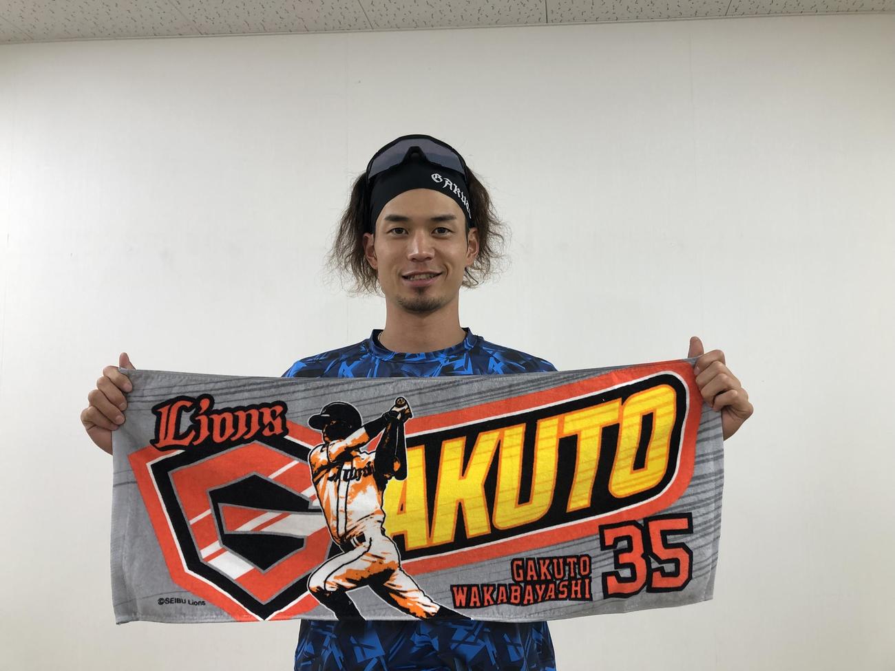アメコミヒーローをイメージした応援タオルを見せる西武若林