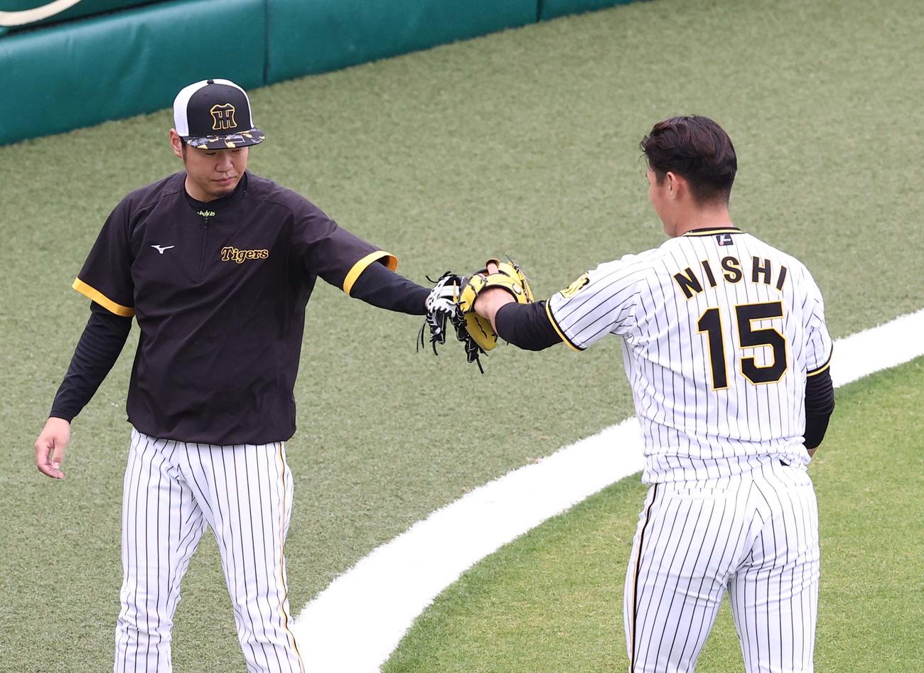 キャッチボールを終え西純（右）とグラブタッチする西勇（撮影・上田博志）
