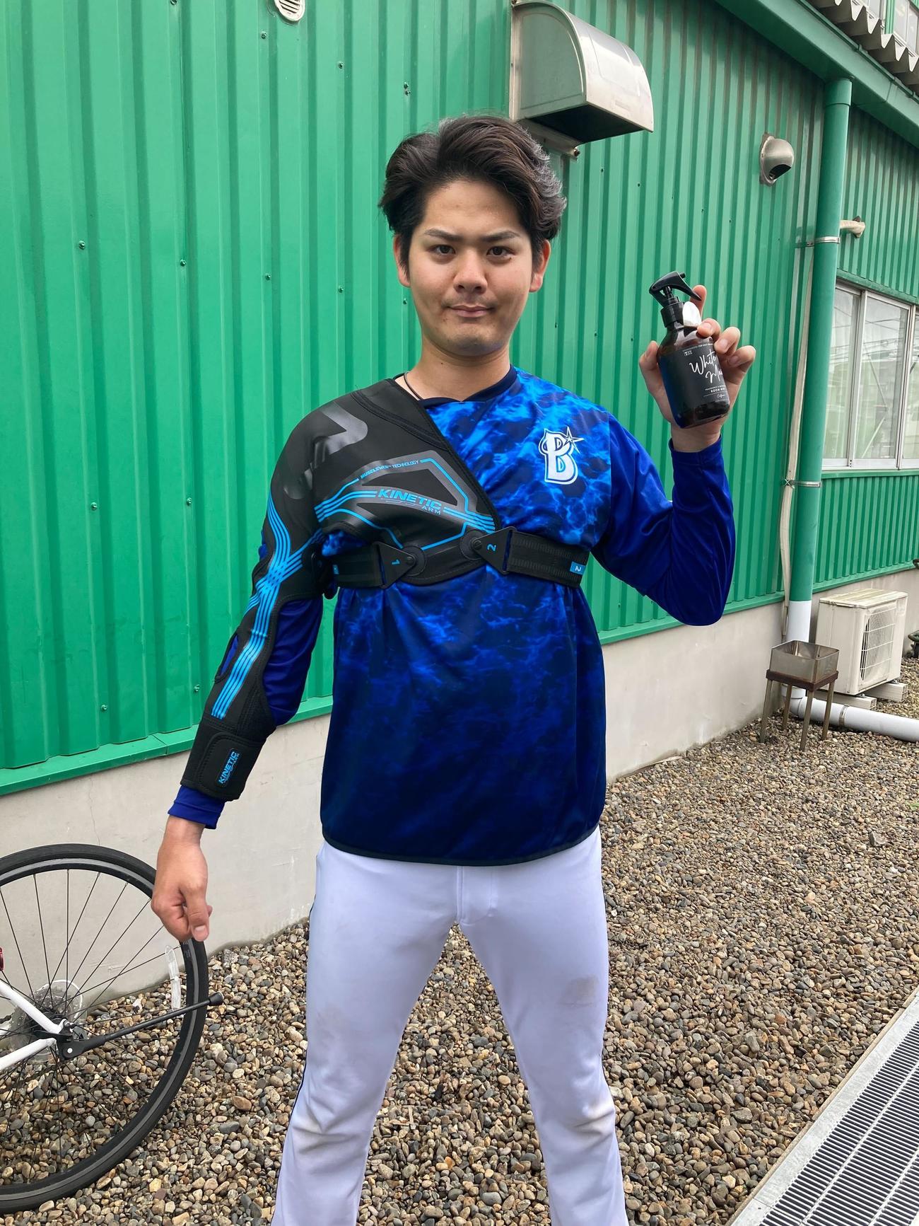 キネティックアームを右肩に装着し、ポーズを決めるDeNA宮城。左手のスプレーは特に意図はないので、スルーでお願いします（球団提供）