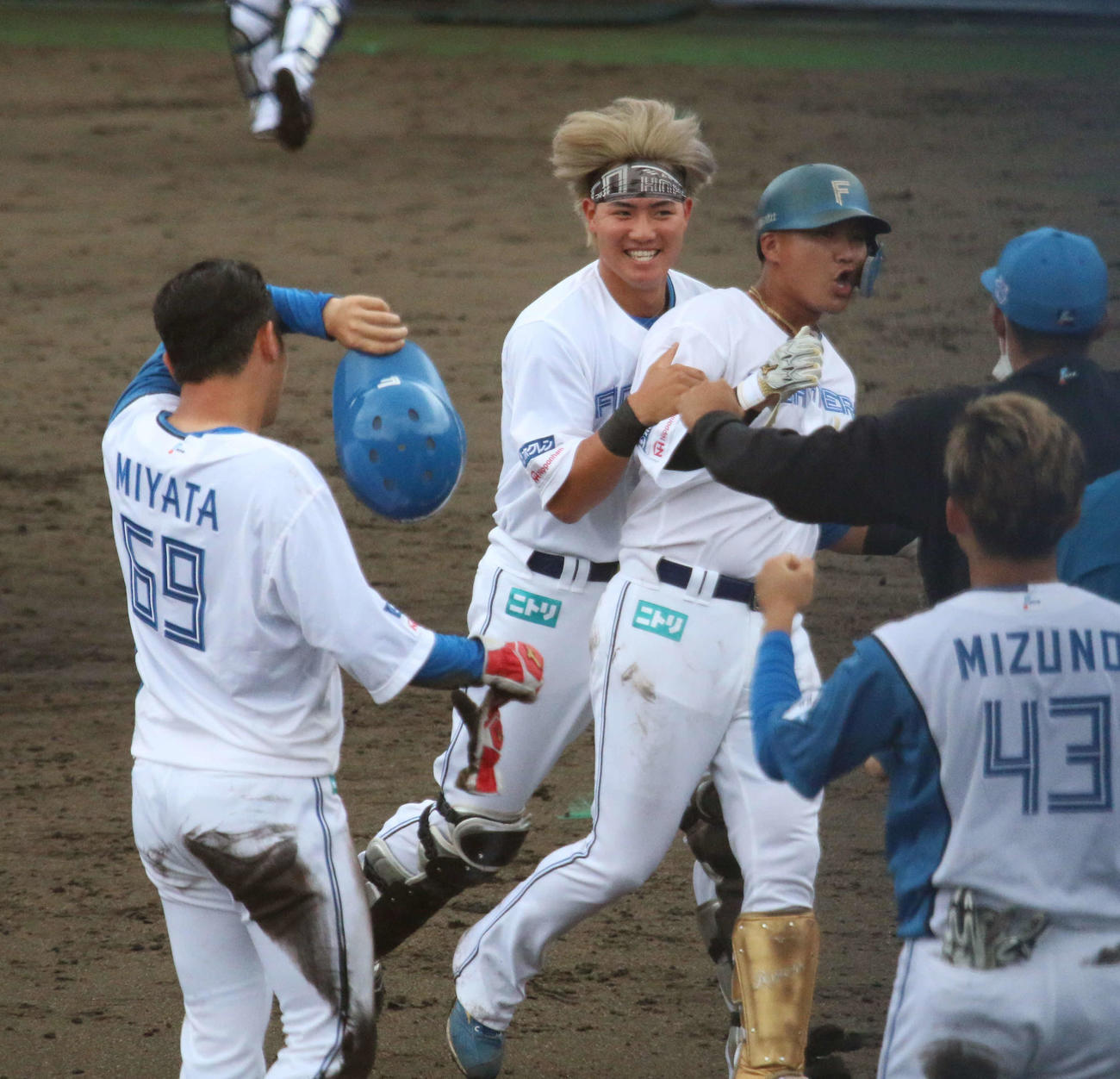 日本ハム対DeNA 9回裏日本ハム2死一、二塁　日本ハム佐藤（左から3人目）はサヨナラ打を放つと郡に抱きつかれる（撮影・木下大輔）