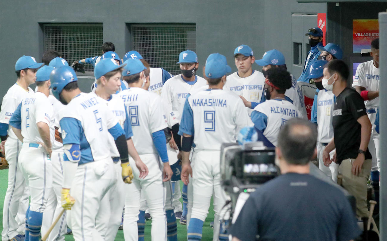 日本ハム対DeNA 4回表終了時、円陣を組む日本ハムナイン。右後方は新庄監督（撮影・佐藤翔太）