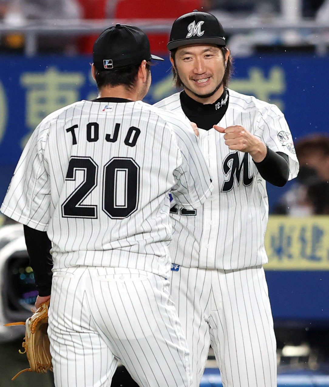 ロッテ対中日　7回表を終え、ロッテ2番手の東條（手前）をタッチで向ける石川（撮影・狩俣裕三）