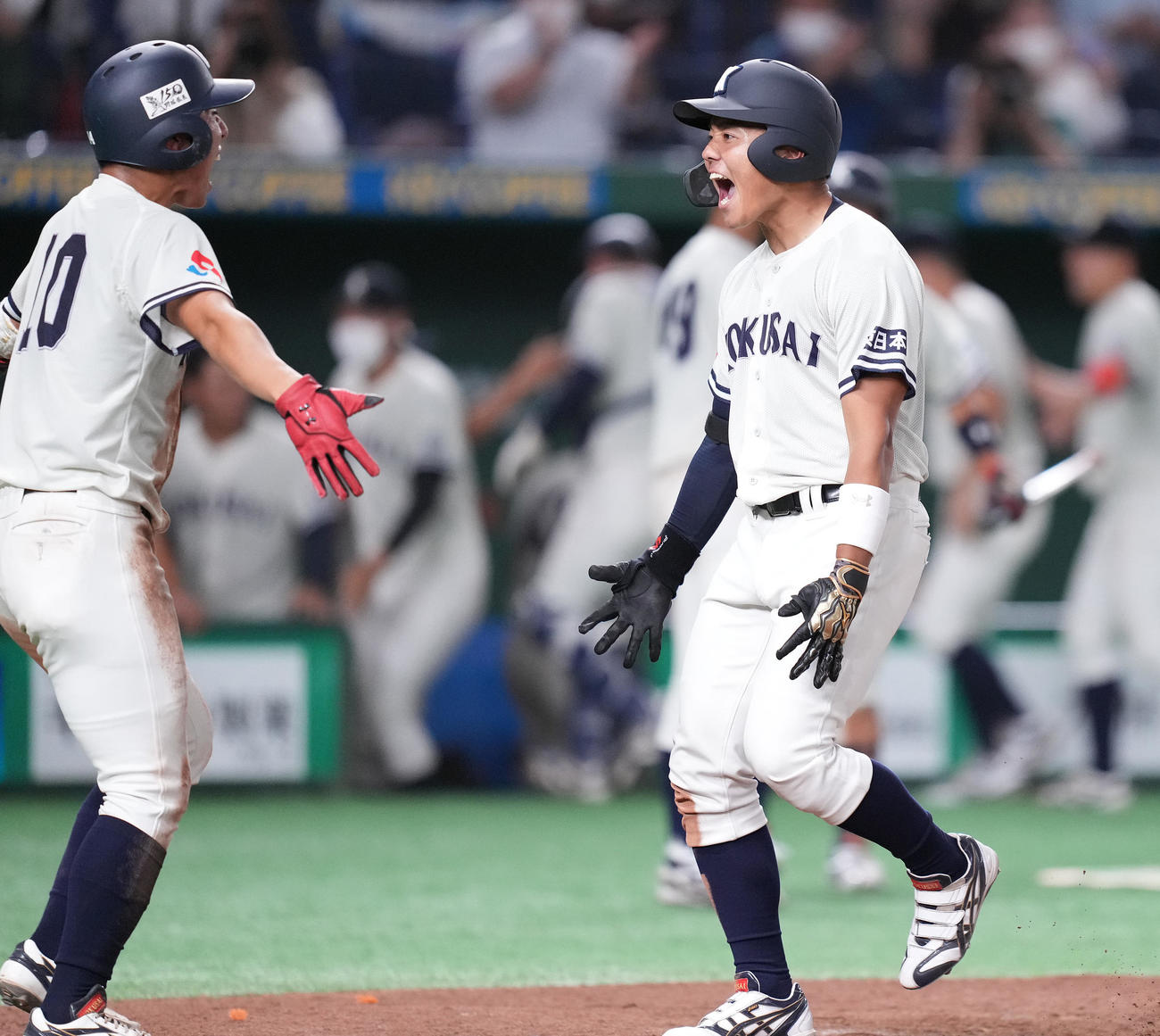 8回表東日本国際大1死一、三塁、右越え3点本塁打を放った上崎は生還し雄たけびを上げる（撮影・鈴木みどり）