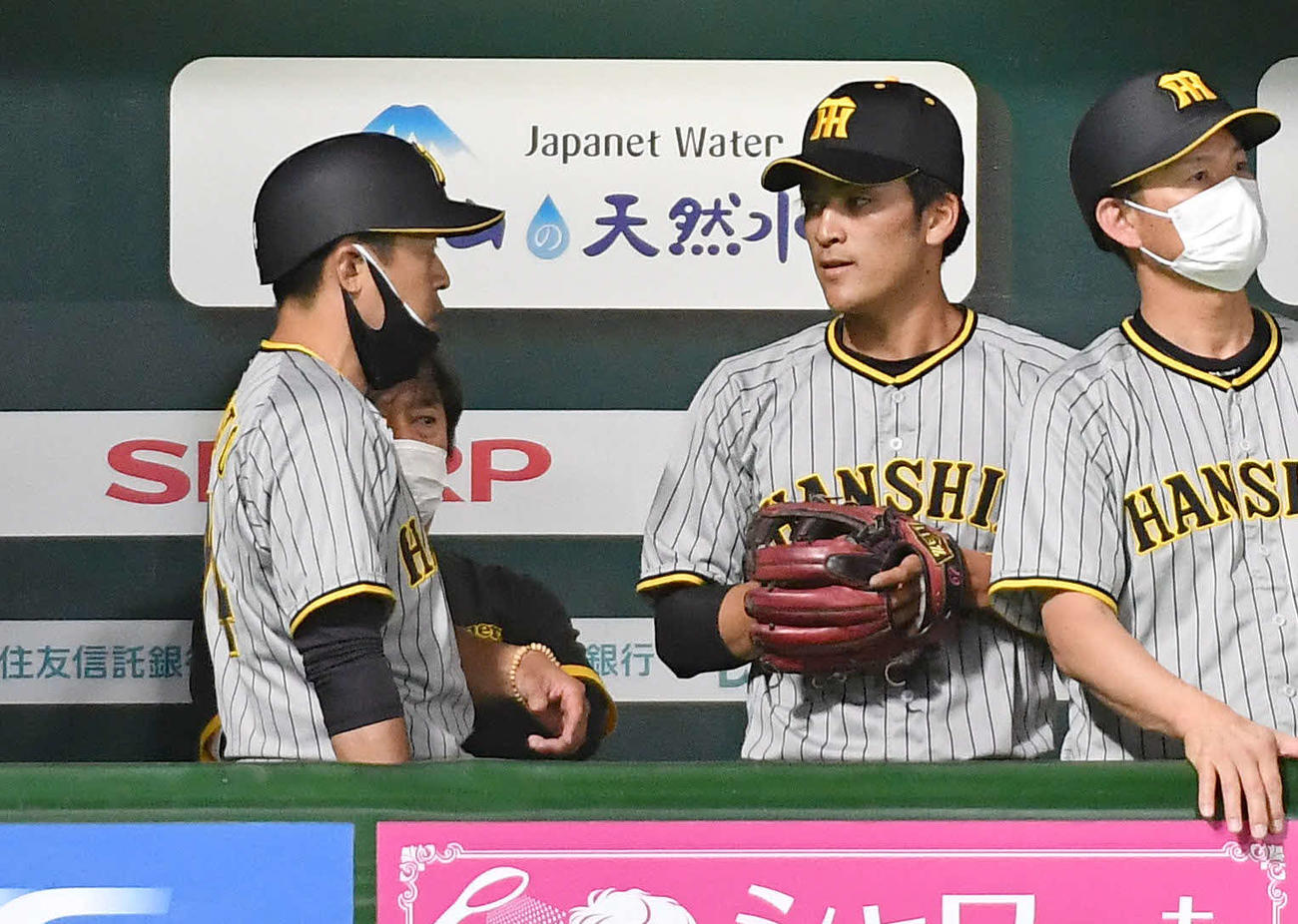 ソフトバンク対阪神　1回裏の守備を終え、ベンチで藤本コーチ（左）と話す高寺（撮影・岩下翔太）