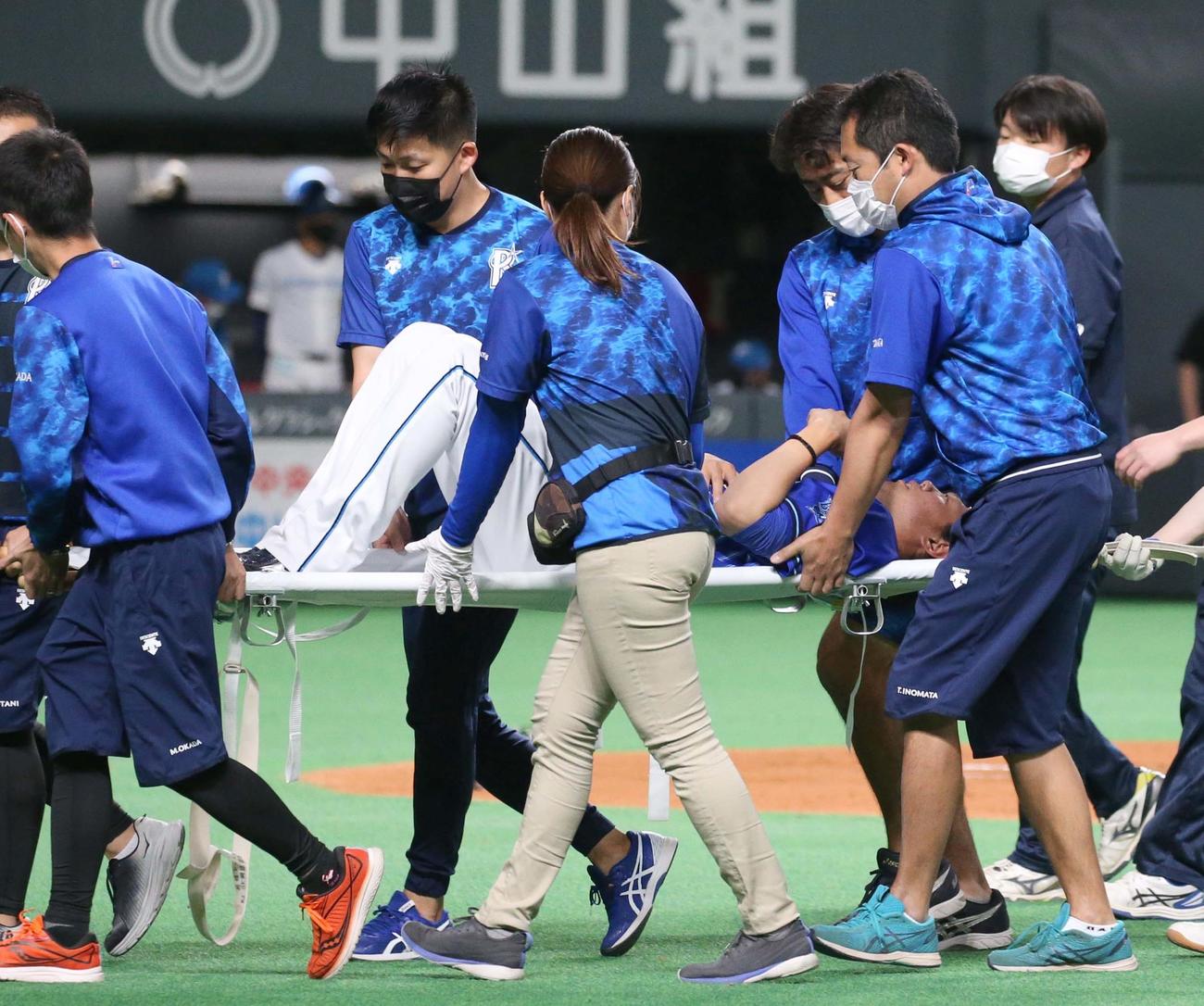 日本ハム対DeNA 3回裏日本ハム無死二塁、石井の右前打の打球でベースカバーに走ろうとして左足を痛め担架で運ばれる上茶谷（撮影・黒川智章）