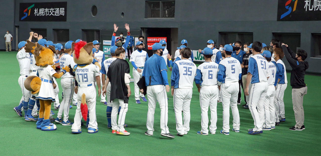 日本ハム対DeNA　試合終了後、ベンチ前で円陣を組み喜び合う日本ハムナインと新庄監督（中央後方）（撮影・佐藤翔太）