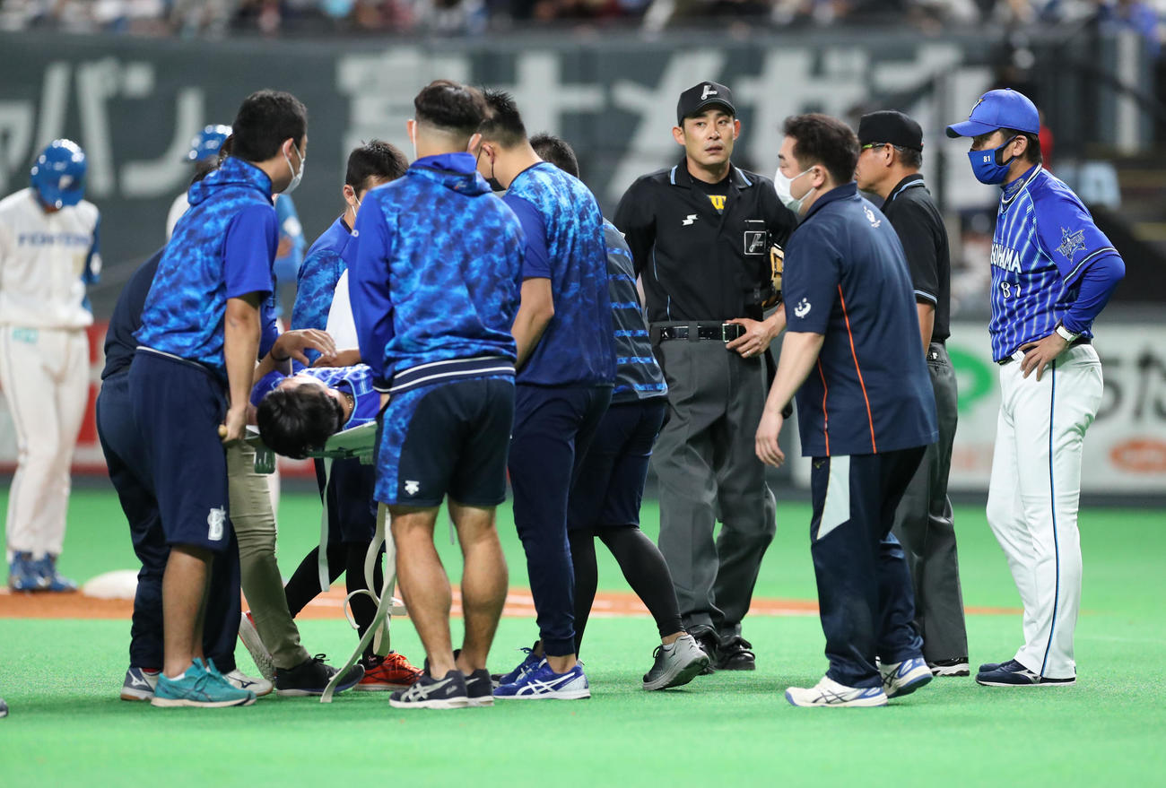 日本ハム対DeNA 3回裏日本ハム無死一、三塁、負傷し担架で運ばれる先発の上茶谷を心配そうに見つめる三浦監督（右）（撮影・佐藤翔太）