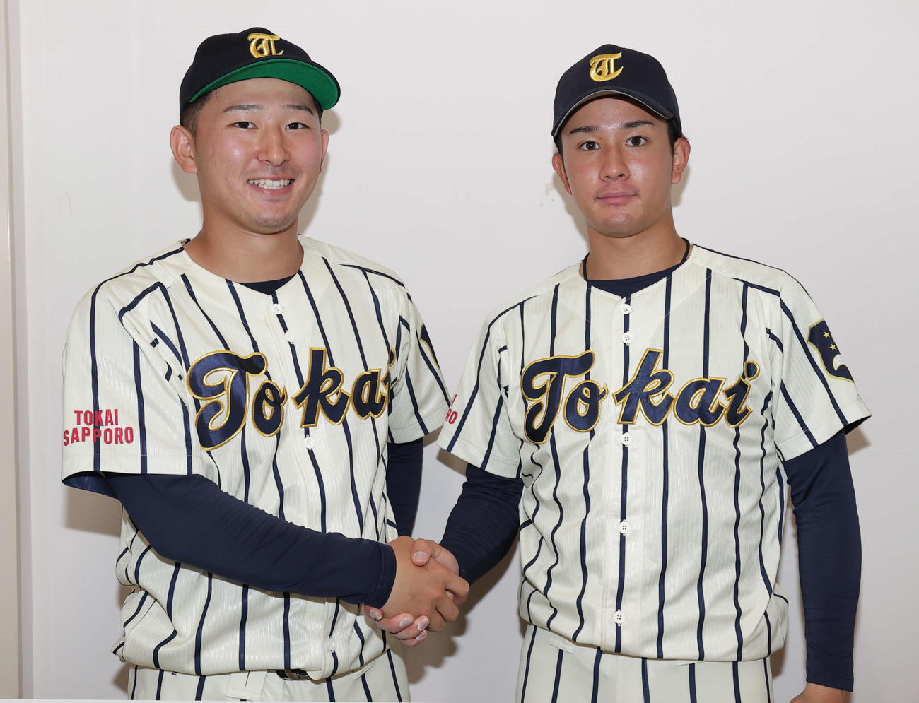 試合後に握手する東海大北海道・相馬主将（左）と先発した登坂（撮影・野上伸悟）