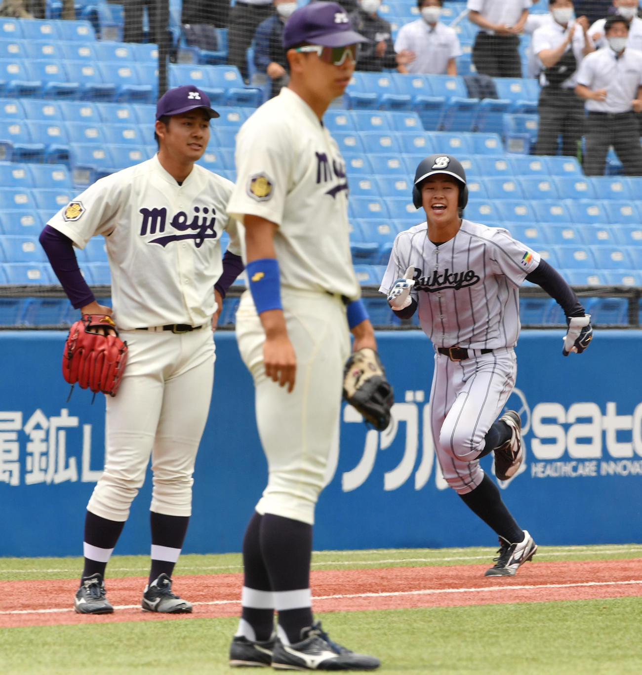 明大対佛教大　タイブレーク10回裏佛教大無死一、二塁、沢崎の送りバントを千葉（左）が一塁に悪送球し二塁走者七條（右）がサヨナラの生還する（撮影・柴田隆二）