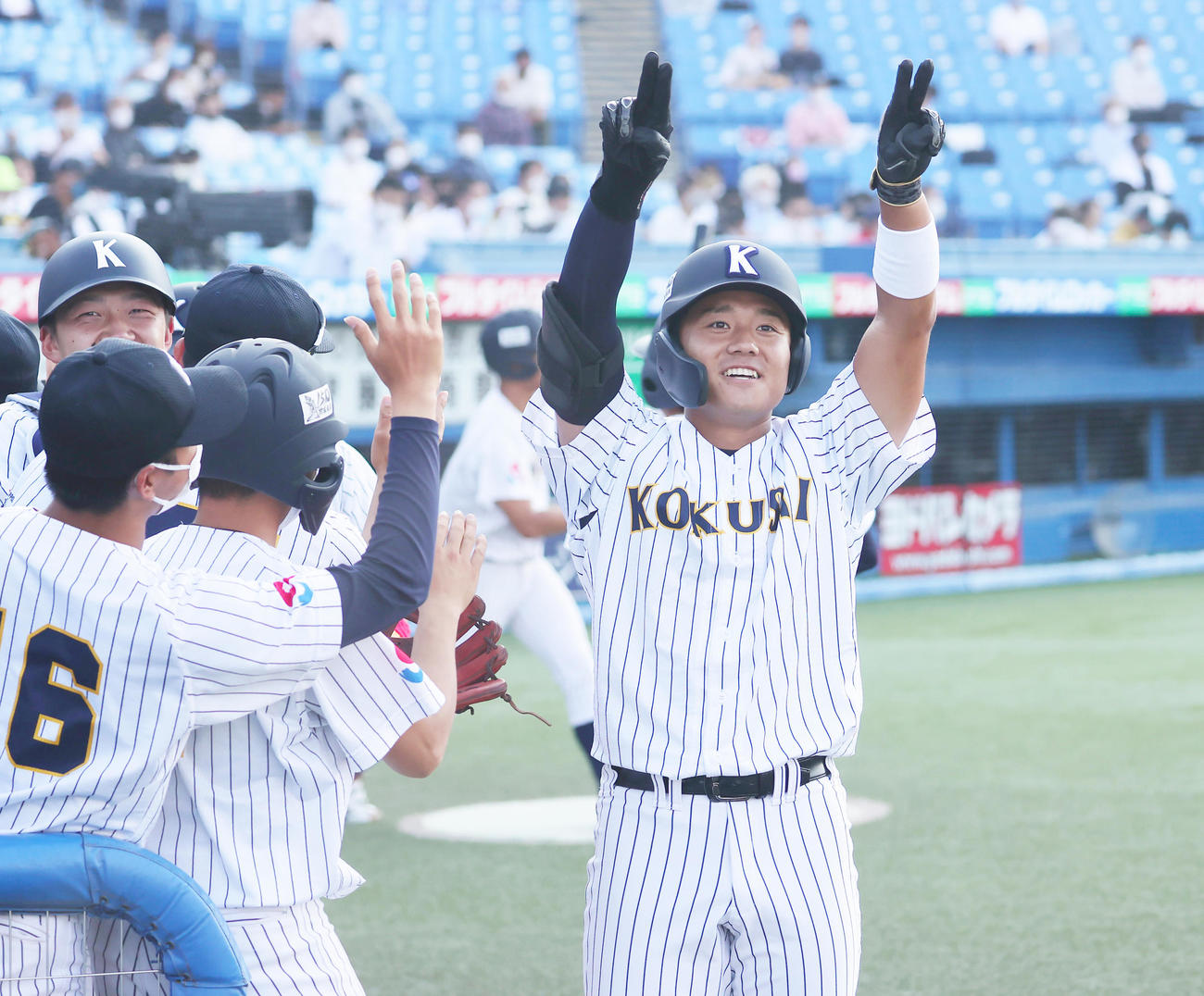 大商大対東日本国際大　1回裏東日本国際大2死一、二塁、右越え先制3点本塁打を放ち、応援席に向かって手を挙げる上崎（撮影・野上伸悟）