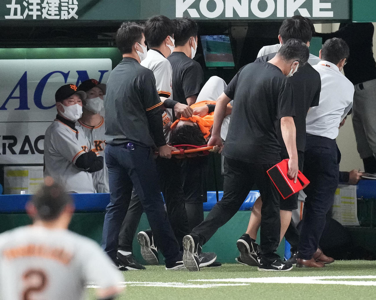 西武対巨人　9回裏西武1死、外崎の飛球を好捕した際に怪我をし、運ばれる右翼手立岡。左は原監督（撮影・鈴木みどり）