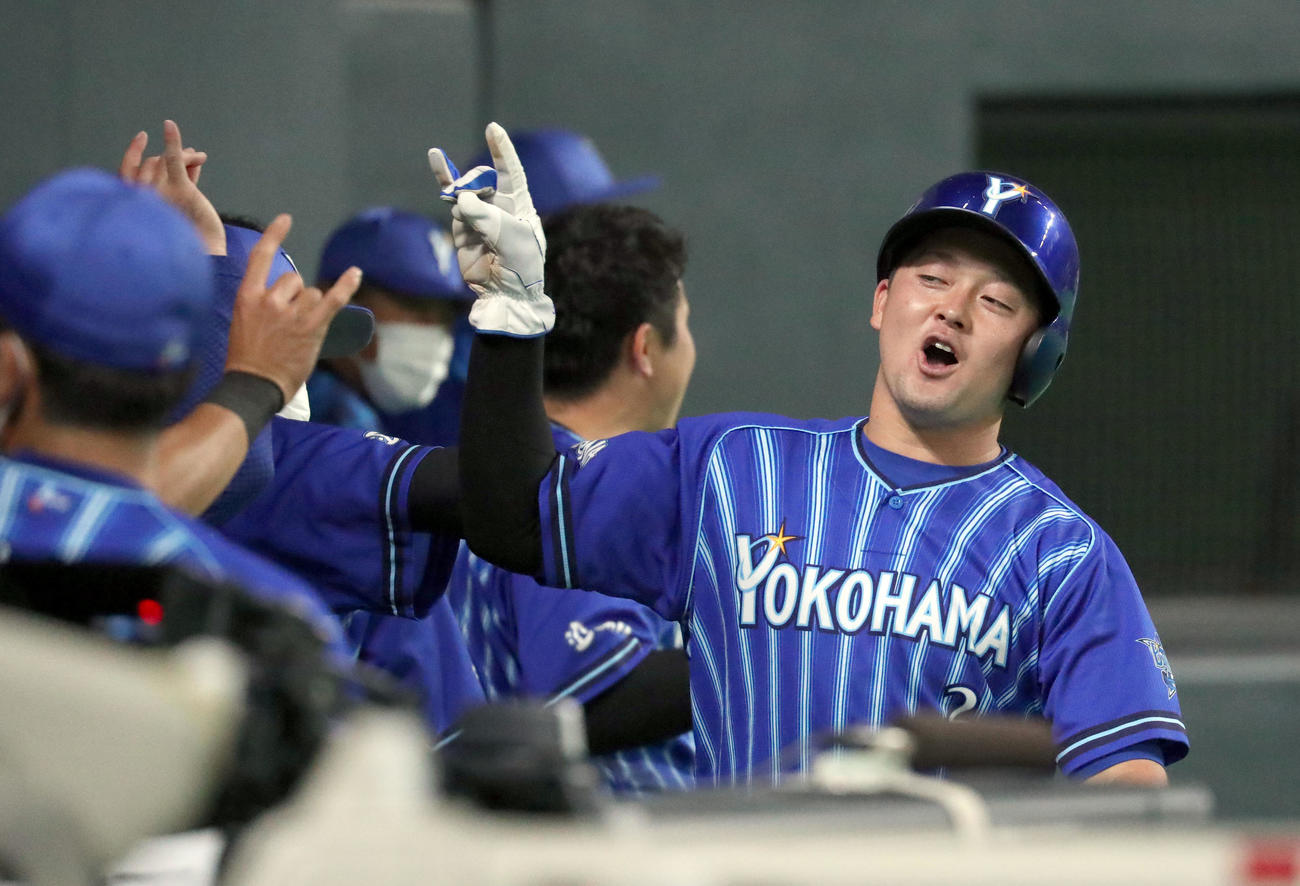 日本ハム対DeNA 8回表DeNA無死三塁、宮崎の右前適時打で生還しチームメートに出迎えられる牧（撮影・佐藤翔太）