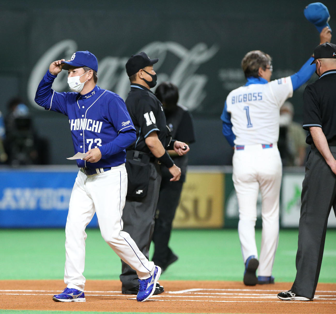 日本ハム対中日　試合前、メンバー表を交換しベンチに引き揚げる中日立浪監督。右後方は日本ハム新庄監督（撮影・佐藤翔太）