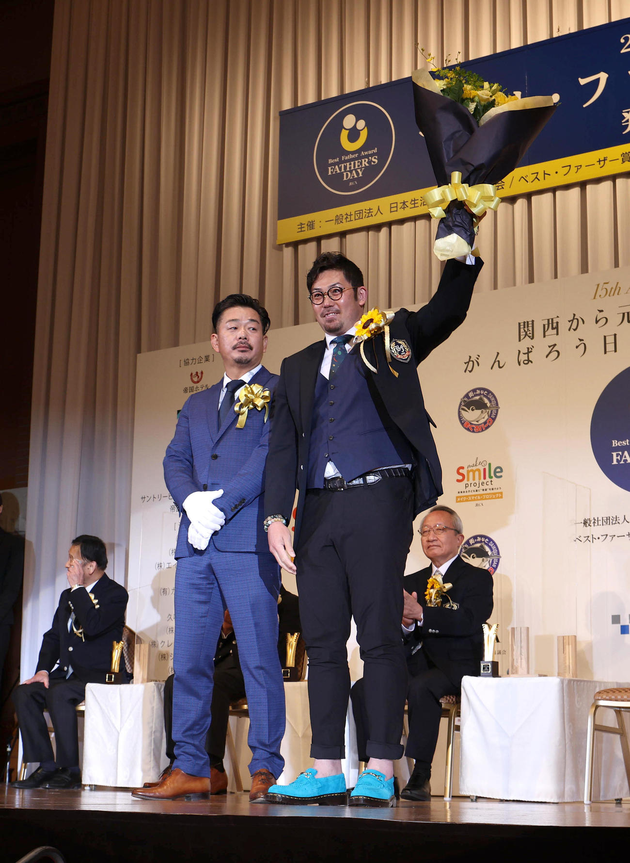 ベストファーザー賞in関西のスポーツ部門賞を受賞し花束を掲げる岩田稔氏（右）（撮影・白石智彦）