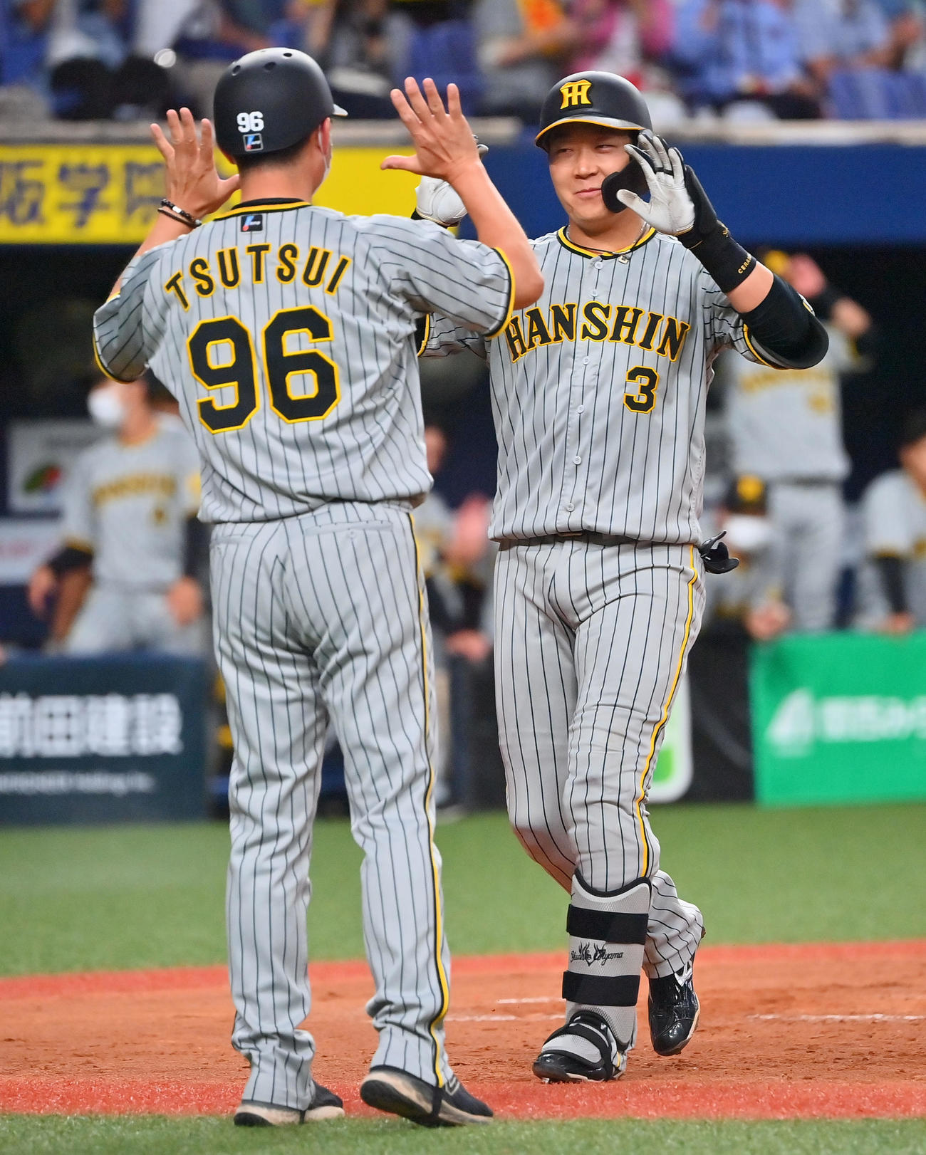 オリックス対阪神　5回表阪神2死一、三塁、左越えに3点本塁打を放った大山（右）は筒井コーチとタッチ（撮影・和賀正仁）