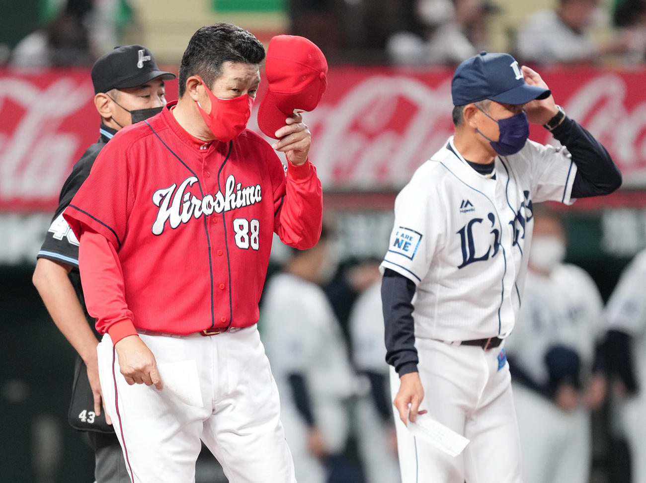 西武対広島　試合開始前、西武辻監督（右）とメンバー表の交換をし、ベンチに戻る広島佐々岡監督（撮影・菅敏）