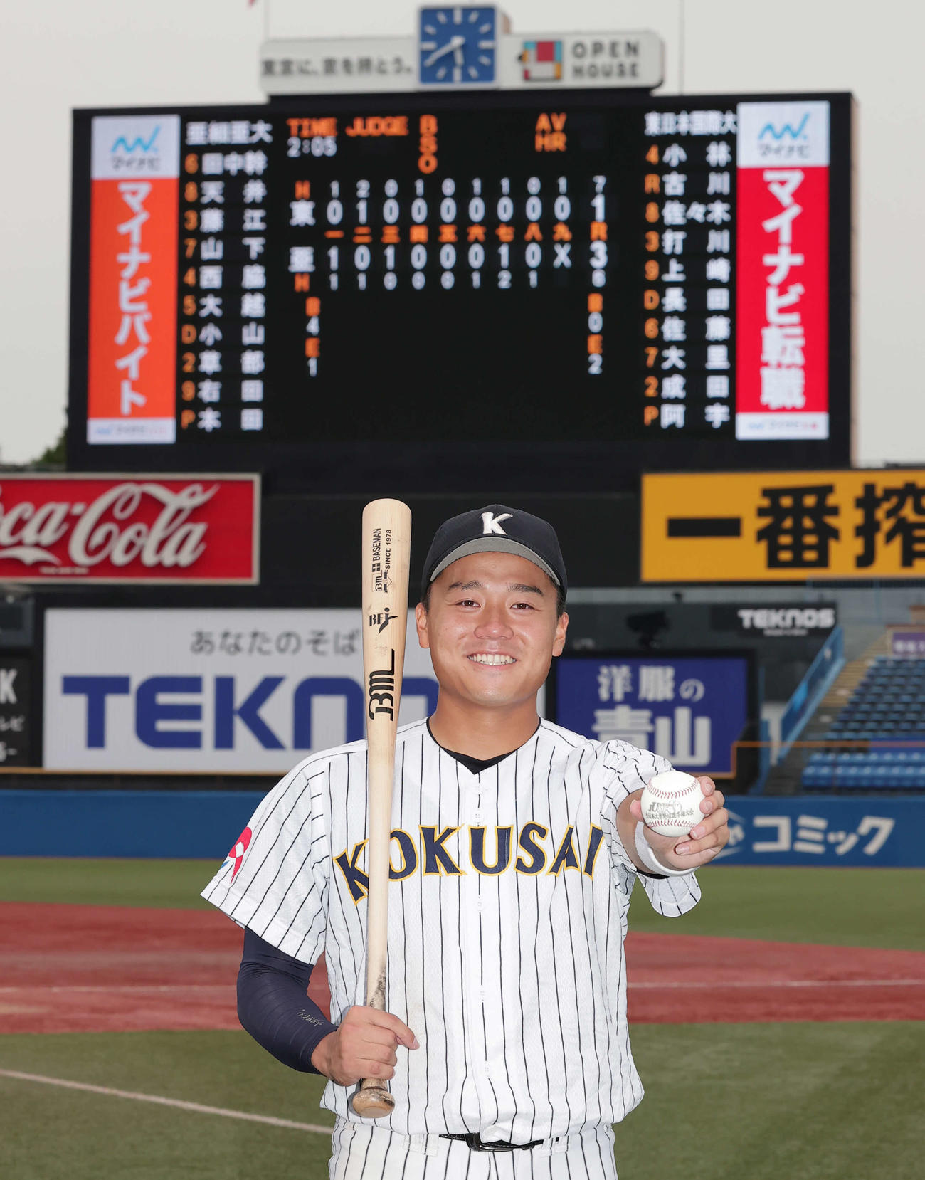 大会新記録の4試合連続本塁打を放った東日本国際大・上崎は記念球とバットを手に笑顔（撮影・野上伸悟）
