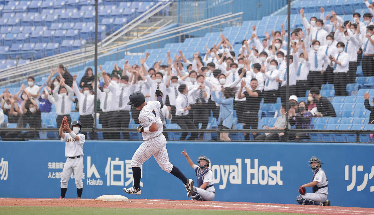東日本国際大対亜大　2回表東日本国際大無死、右越えに大会新記録となる4戦連続本塁打を放ち、盛り上がる応援席の前で一塁を回る上崎（撮影・野上伸悟）