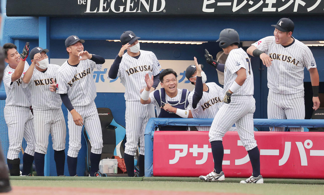 東日本国際大対亜大　2回表東日本国際大無死、右越えに大会新記録となる4戦連続本塁打を放ちベンチの仲間に迎えられる上崎（撮影・野上伸悟）
