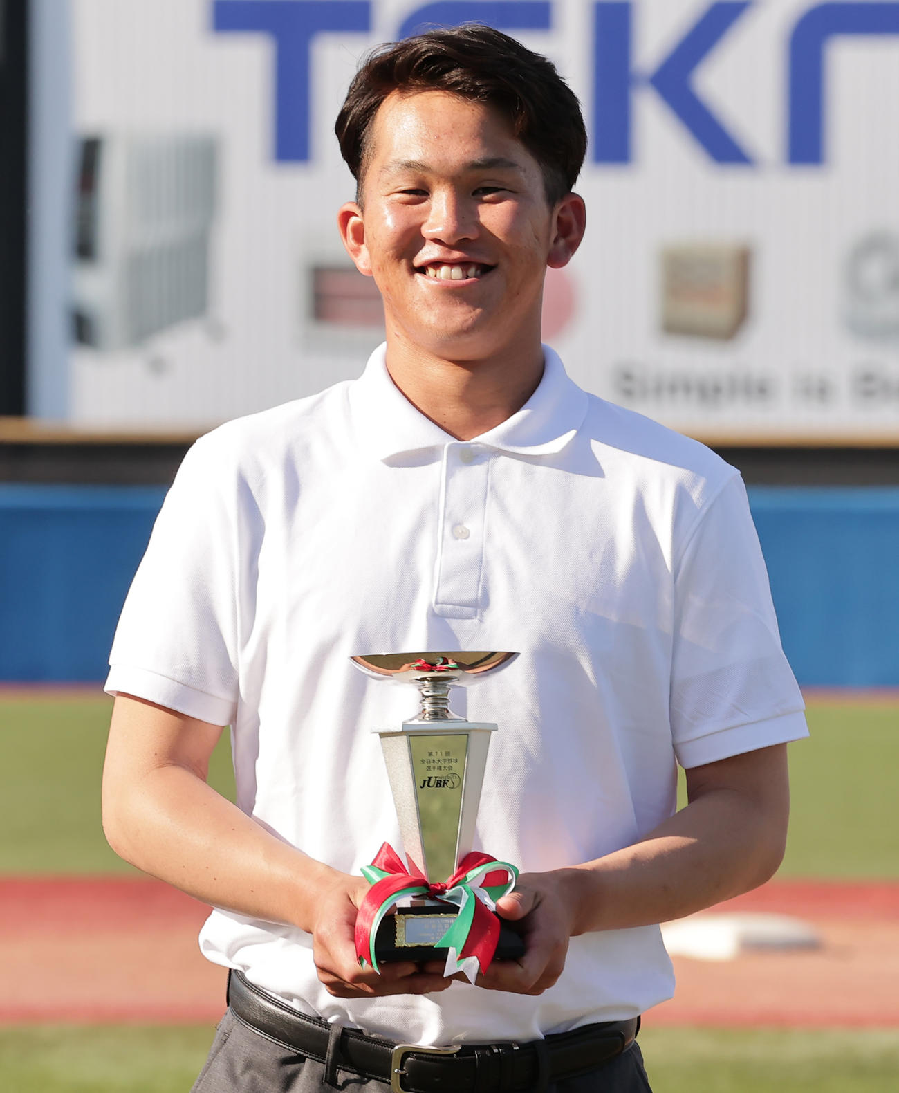 最優秀投手賞を受賞し、トロフィーを手に笑顔を見せる佛教大・山本（撮影・野上伸悟）