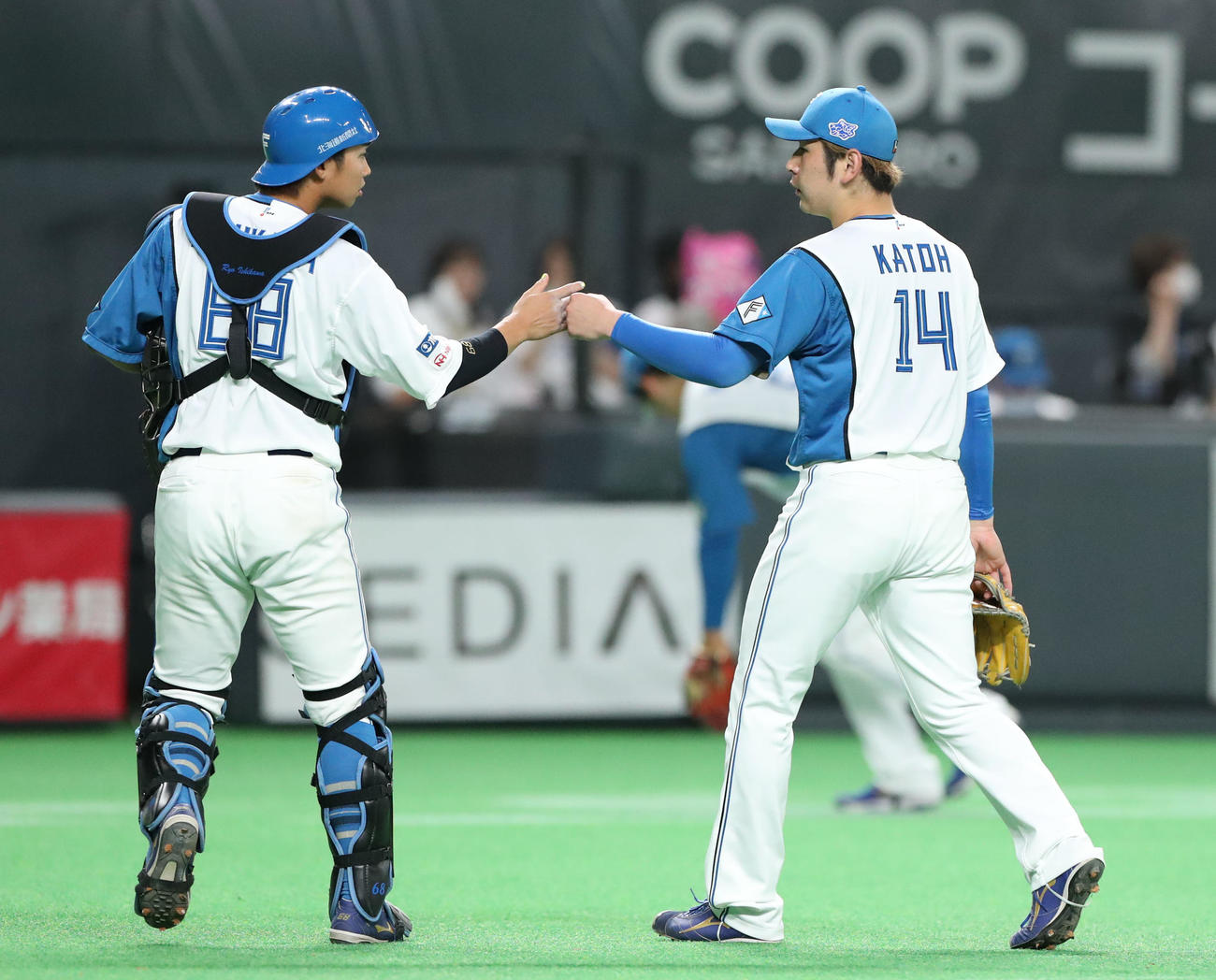 日本ハム対中日　グータッチを交わしながらベンチに戻る日本ハム石川亮（左）と加藤（撮影・佐藤翔太）