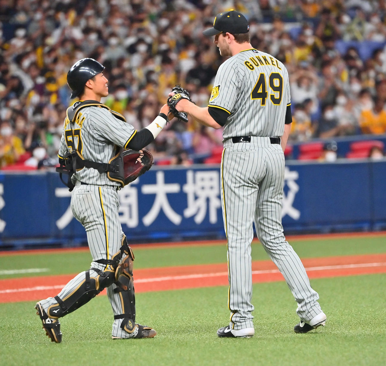 オリックス対阪神　1失点で完投し長坂（左）とタッチする阪神ガンケル（撮影・和賀正仁）