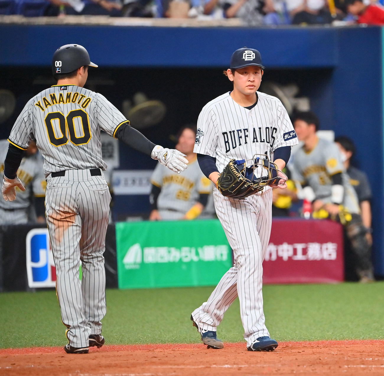 オリックス対阪神　5回表阪神2死満塁、大山に適時打を浴び生還した阪神山本（左）からマスクを受け取る宮城（撮影・和賀正仁）