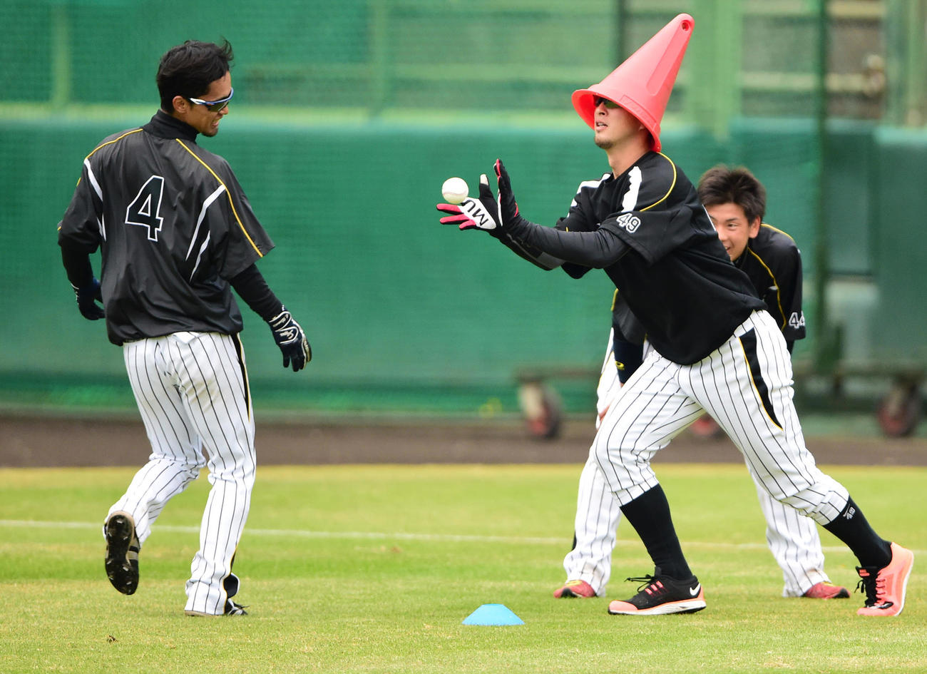 阪神秋季キャンプ　強化ランニングでなぜか三角コーンを頭にかぶる今成亮太（右）。左は上本博紀（2014年11月17日）