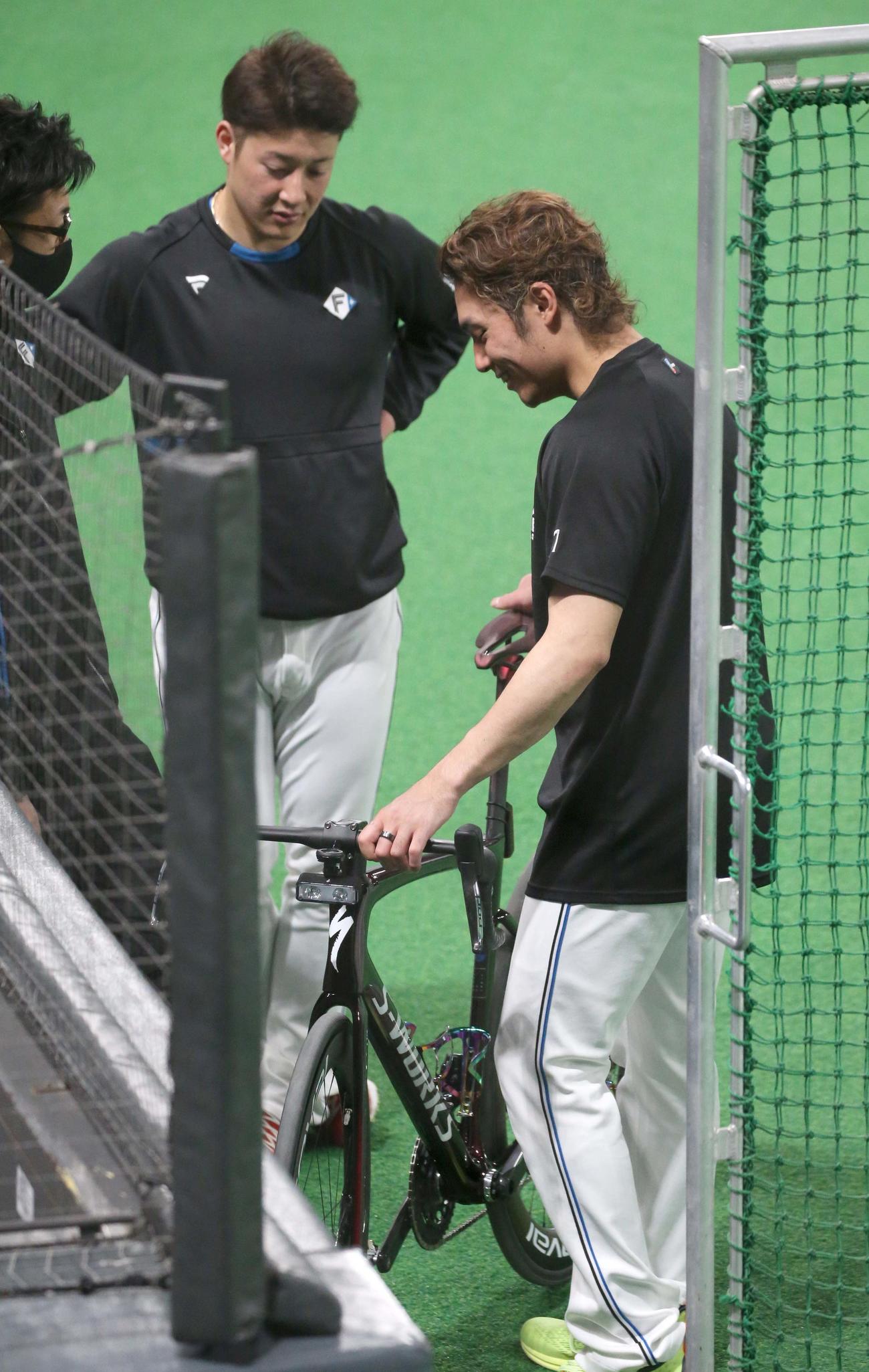 日本ハム新庄監督のロードバイクを触る伊藤（右）と吉田（撮影・黒川智章）