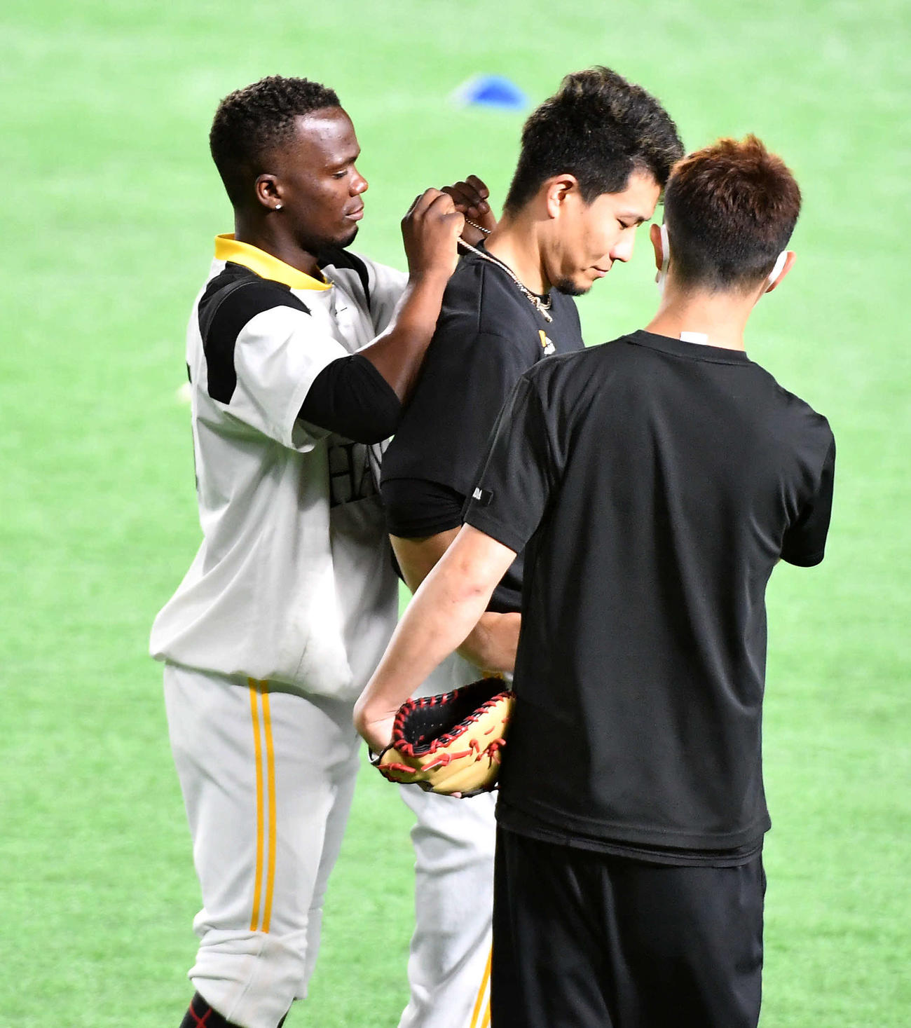 モイネロ（左）がかけていたネックレスをつけてもらう千賀（撮影・岩下翔太）