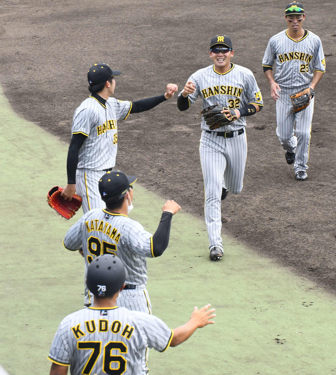 ウエスタンリーグ・オリックス－阪神　3回裏2死一塁、頓宮の左翼への二塁打に対し、スムーズな中継プレーで一塁走者を本塁アウトにした阪神井上は、先発才木（左）とグータッチでベンチに戻る（撮影・中野椋）
