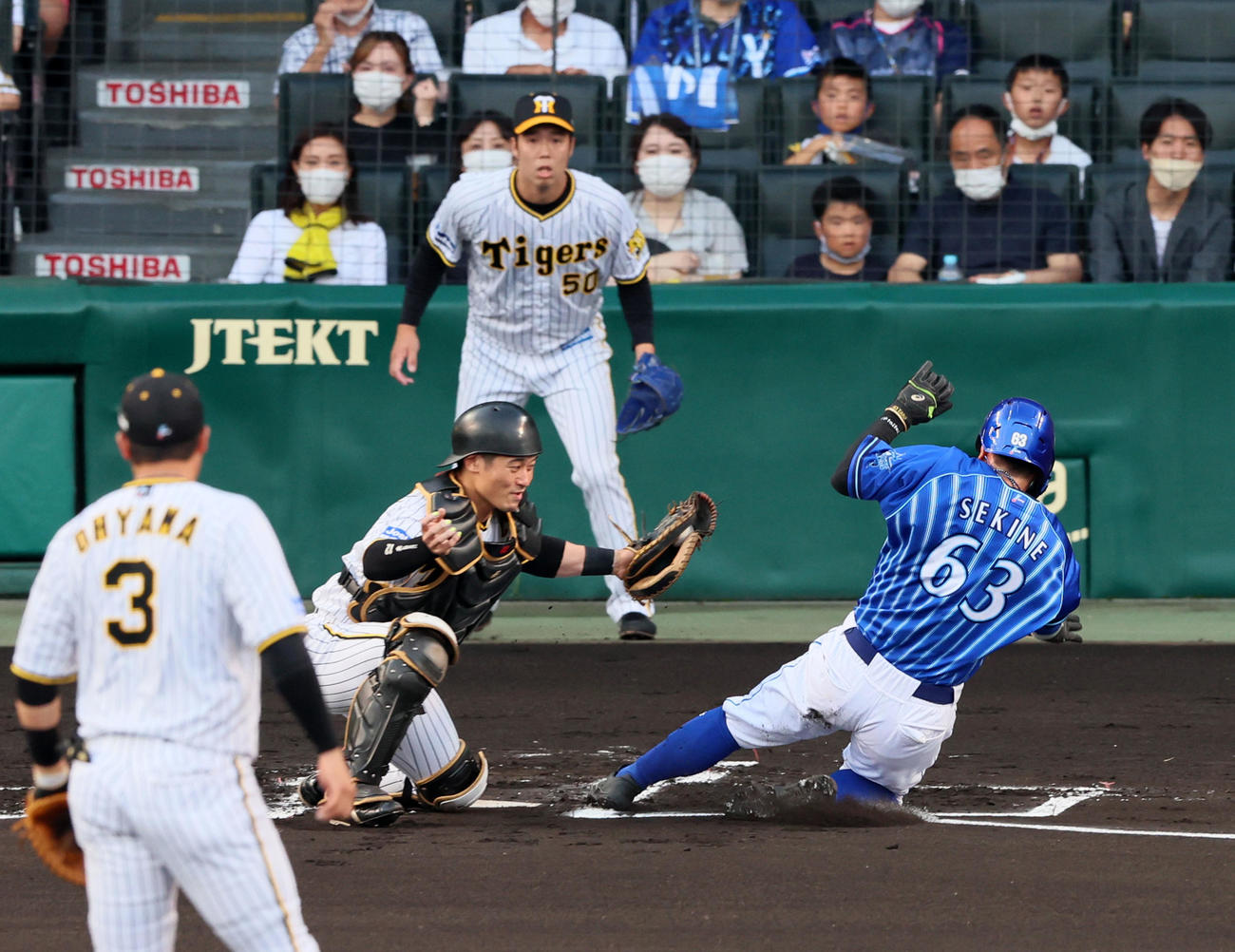 阪神対DeNA 1回表DeNA1死一、三塁、三塁走者関根は牧の左犠飛で生還。捕手は坂本（撮影・加藤哉）