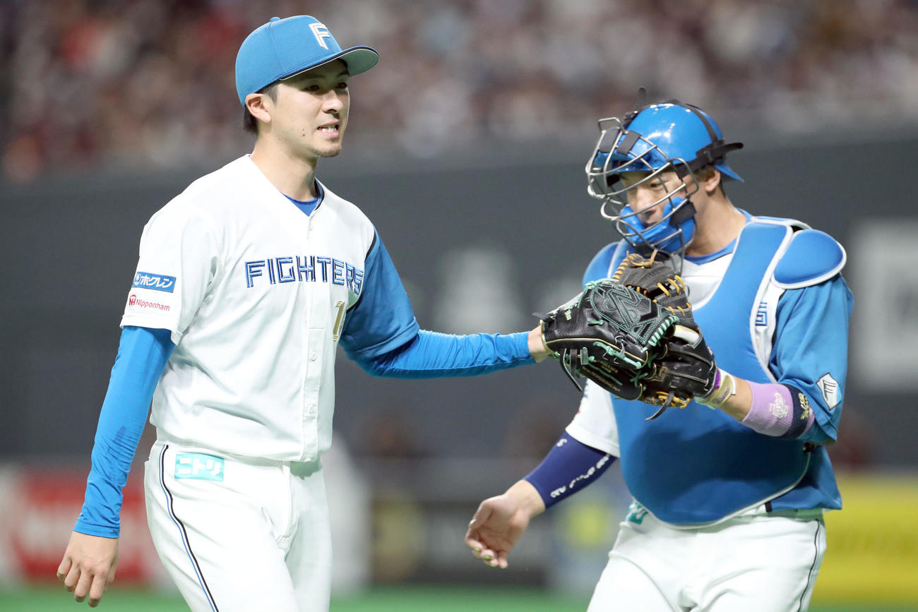 日本ハム対ロッテ　6回表を無失点に抑えタッチを交わしながらベンチに戻る上沢（左）と宇佐見（撮影・佐藤翔太）