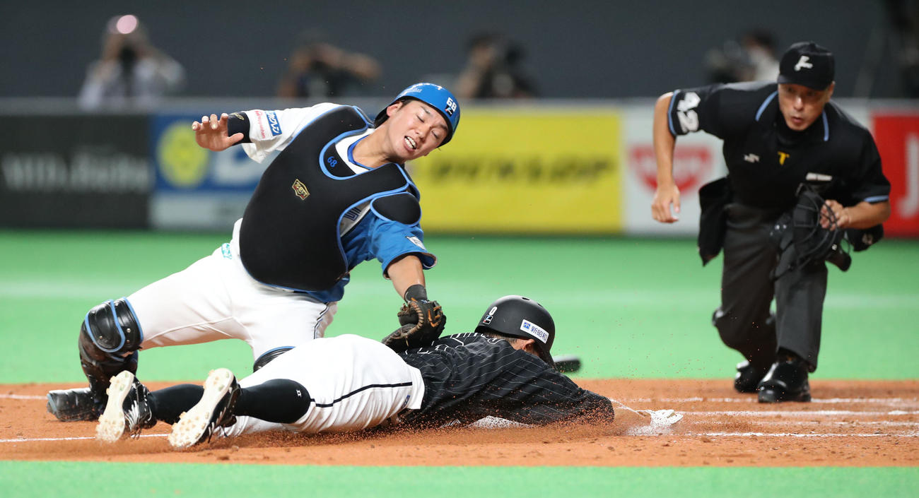 日本ハム対ロッテ　3回表ロッテ2死満塁、山口の先制となる適時打で生還する荻野。捕手は石川亮（撮影・佐藤翔太）
