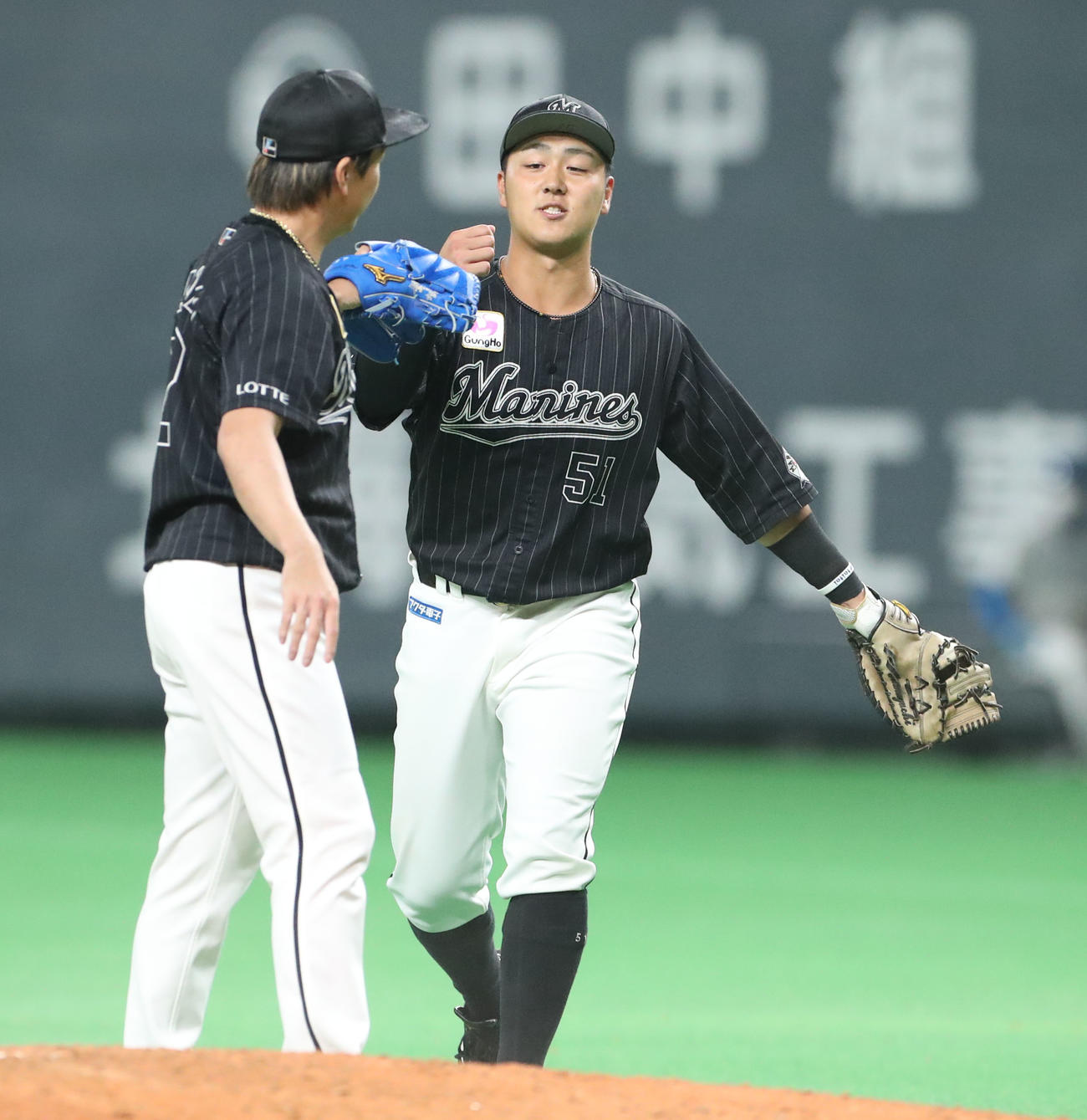 日本ハム対ロッテ　試合終了後、ロッテ益田（左）とタッチを交わす山口（撮影・佐藤翔太）